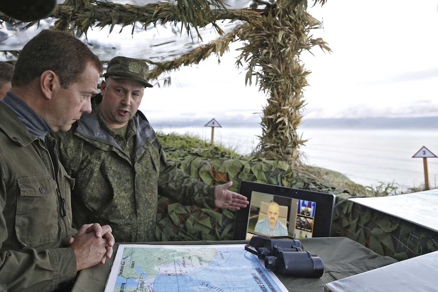 Russian Prime Minister Dmitry Medvedev inspects a machine gun regiment during his visit to Iturup Island.