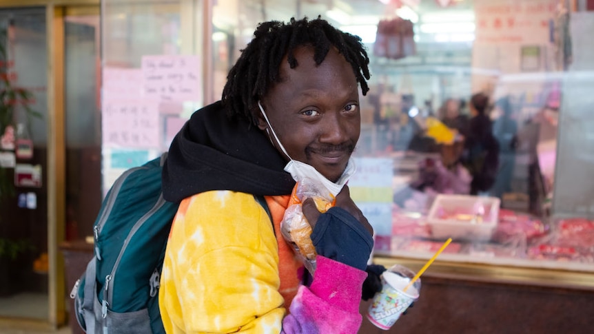 A man poses for a photo while wearing a protective face mask in Haymarket, Sydney.