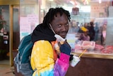 A man poses for a photo while wearing a protective face mask in Haymarket, Sydney.