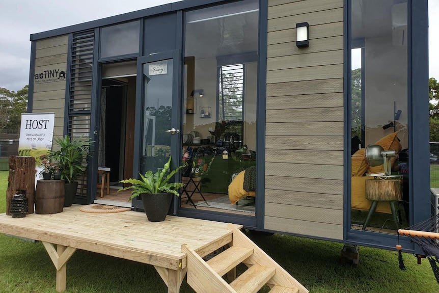 A small house with a little timber deck out front.