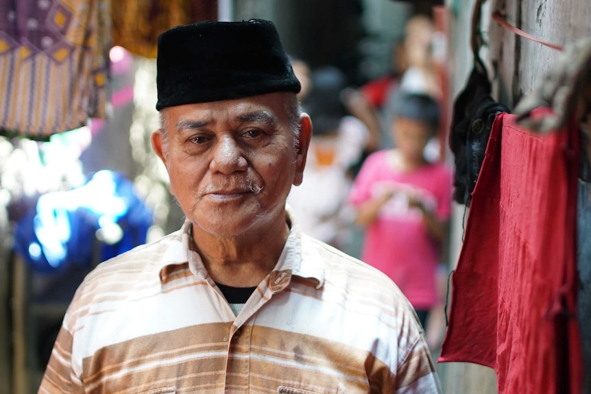 Elderly man standing in alleyway of Tambora slum in West Jakarta, Indonesia. April 2017.