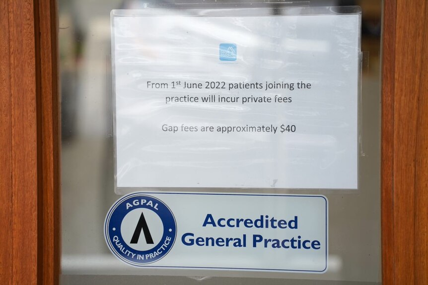 A sign on the door of GP practice which says "From 1st of June 2022 patients joining the practice will incur private fees. 