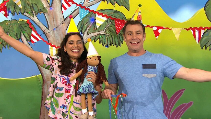 Teo and Leah and Kiya wearing party hats and with party decorations on the Play School set