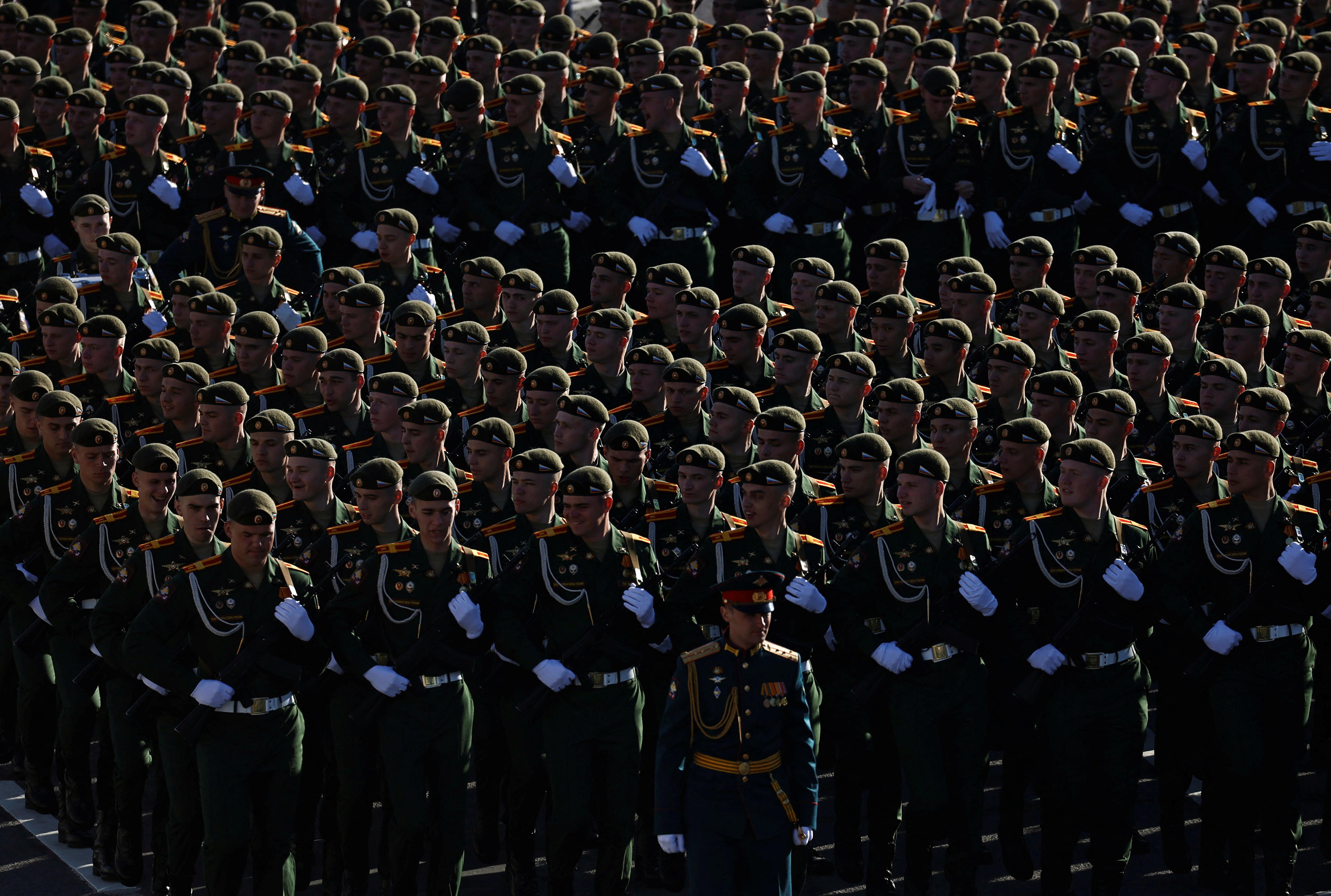 A large number of Russian soldiers standing in perfect columns with white gloves standing out. 