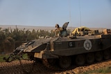 An Israeli soldier rides in an armoured personnel carrier in Gaza.