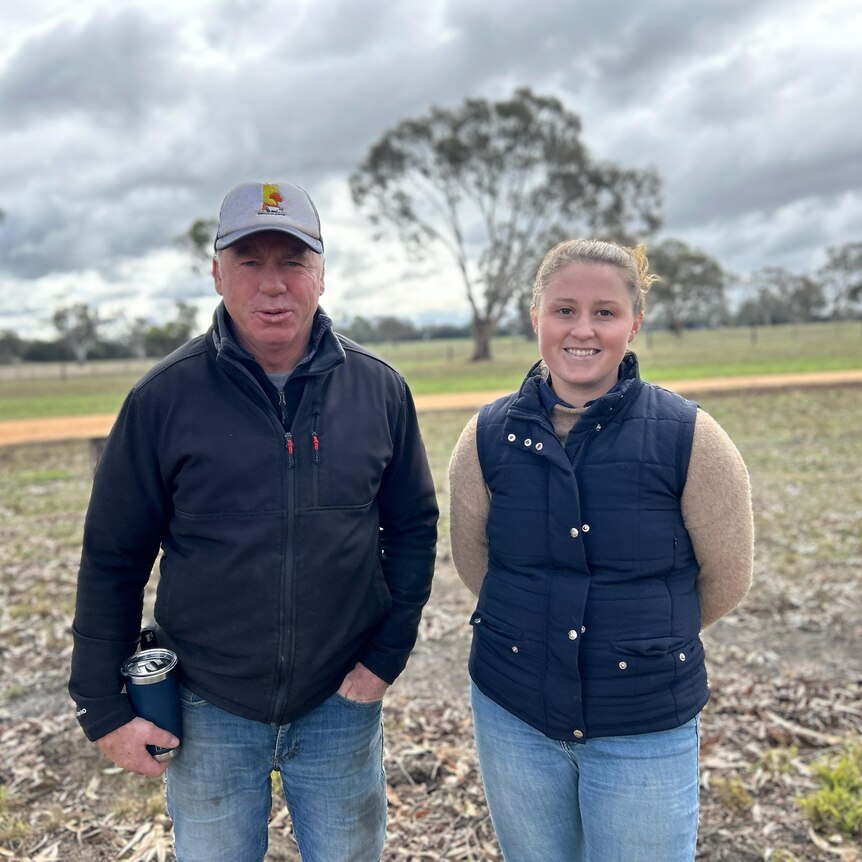 Two people standing in a paddock