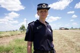 Police officer in uniform standing next to road