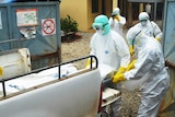 Red Cross workers in Guinea carry the body of an Ebola victim in near a hospital in Conakry on September 14, 2014.