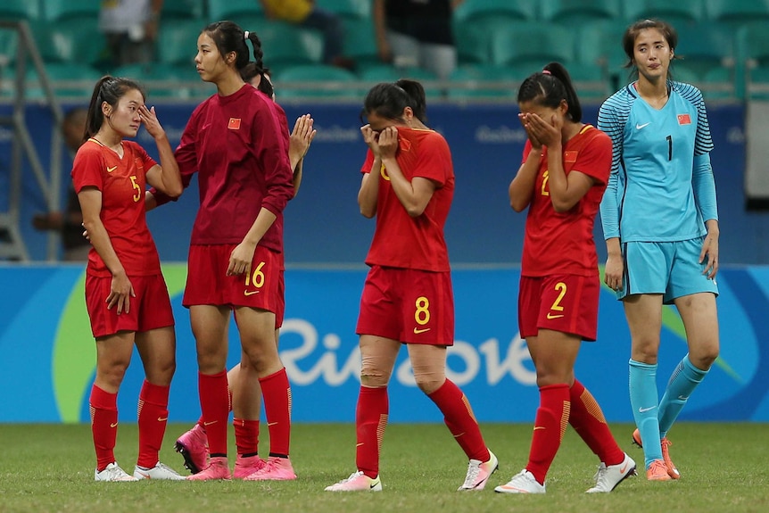 Women's football players wipe tears away after a loss in a knockout match at the Rio Olympics.