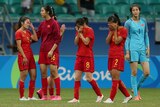 Women's football players wipe tears away after a loss in a knockout match at the Rio Olympics.
