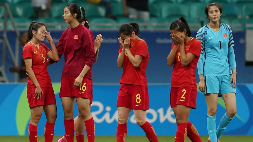 Women's football players wipe tears away after a loss in a knockout match at the Rio Olympics.