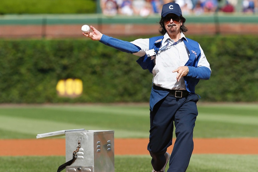 Stephen Colbert, playing Wrigley Field hot dog vendor Donny Franks, throws first pitch at Cubs game.