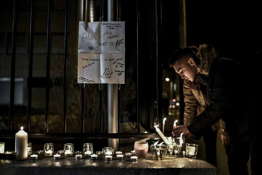 A student lights a candle outside the Saint-Exupery high school in Lyon, central-eastern France, on January 13, 2016.