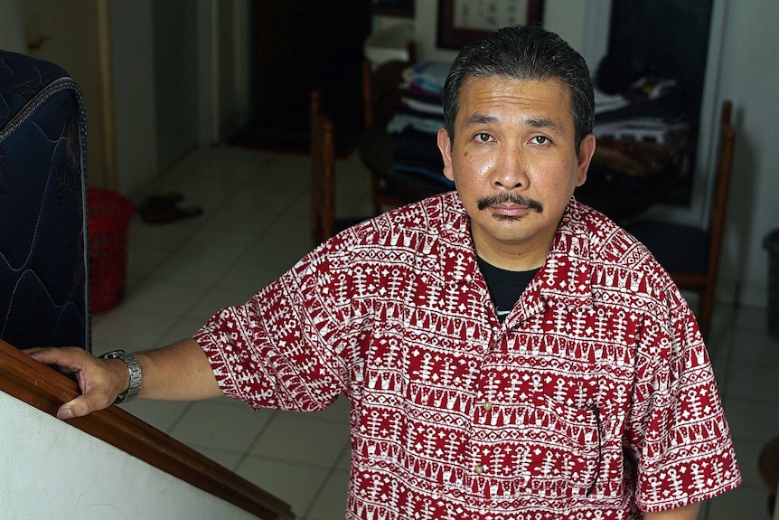 Head and shoulders shot of neatly dressed Indonesian man looking at the camera
