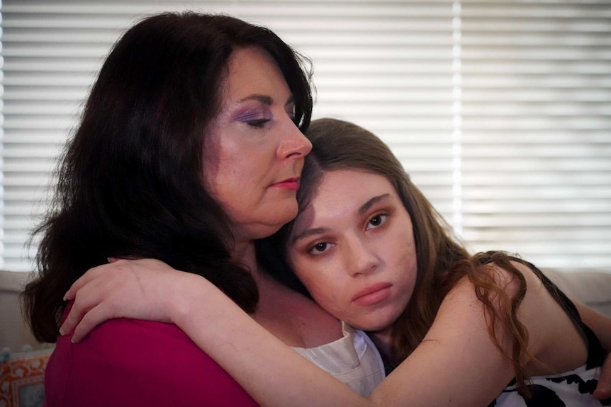 Headshot of a mother holding her teenage daughter