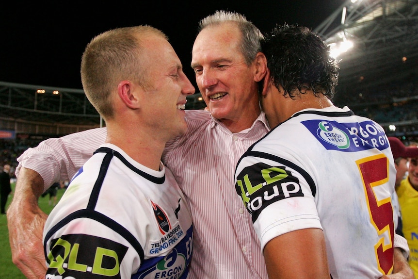 Wayne Bennett hugs Brisbane Broncos players Darren Lockyer and Karmichael Hunt after the 2006 grand final.