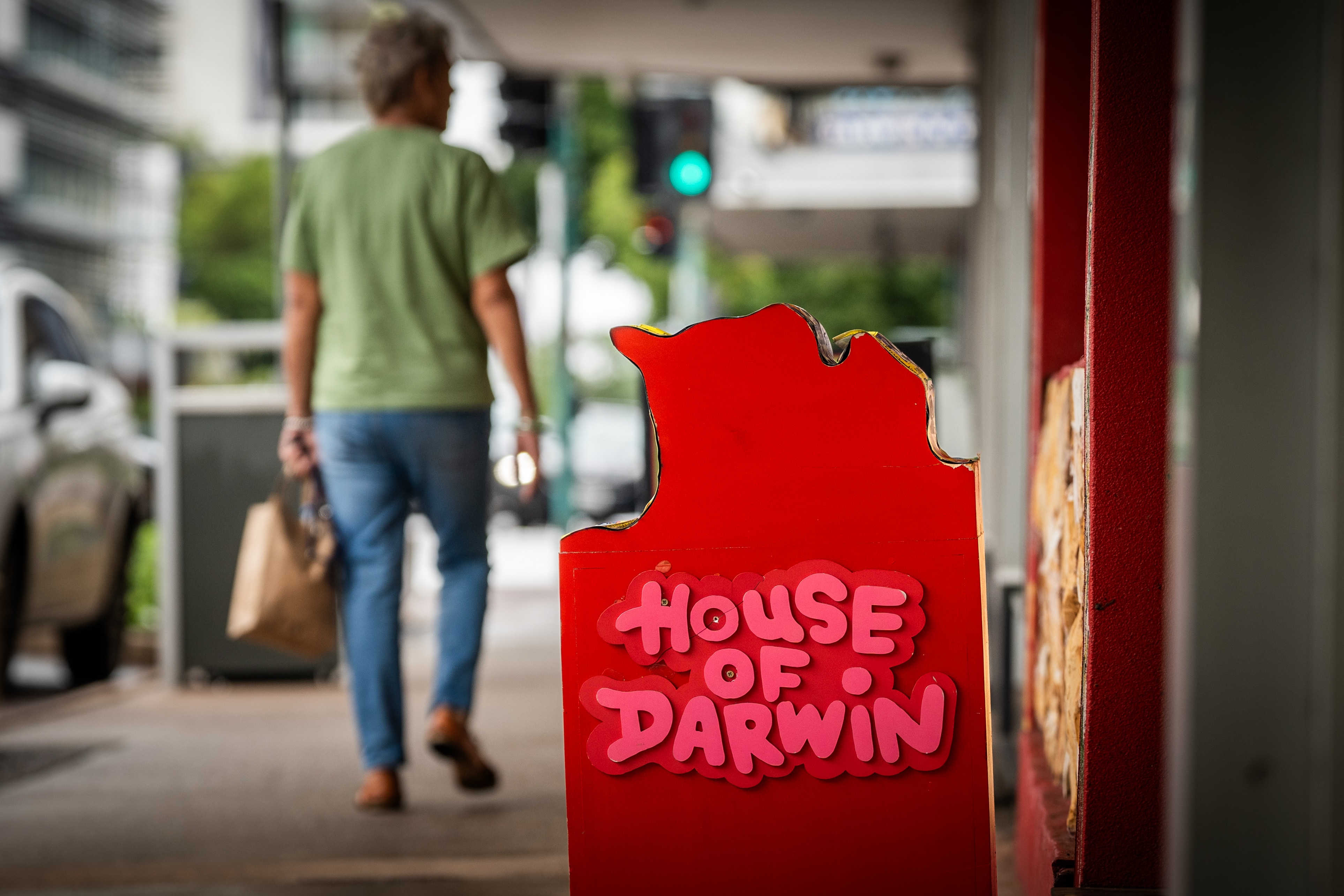 una placa con el nombre "Casa de Darwin" se encuentra frente a una tienda en una calle.