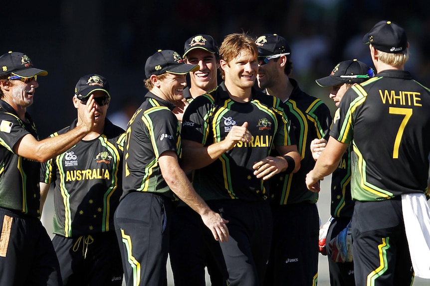 Shane Watson smiles as he is surrounded by teammates.