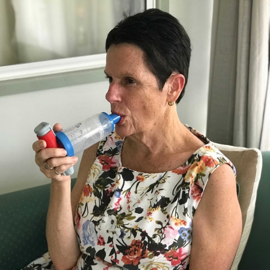 Colleen Carmody sitting inside her home using her inhaler