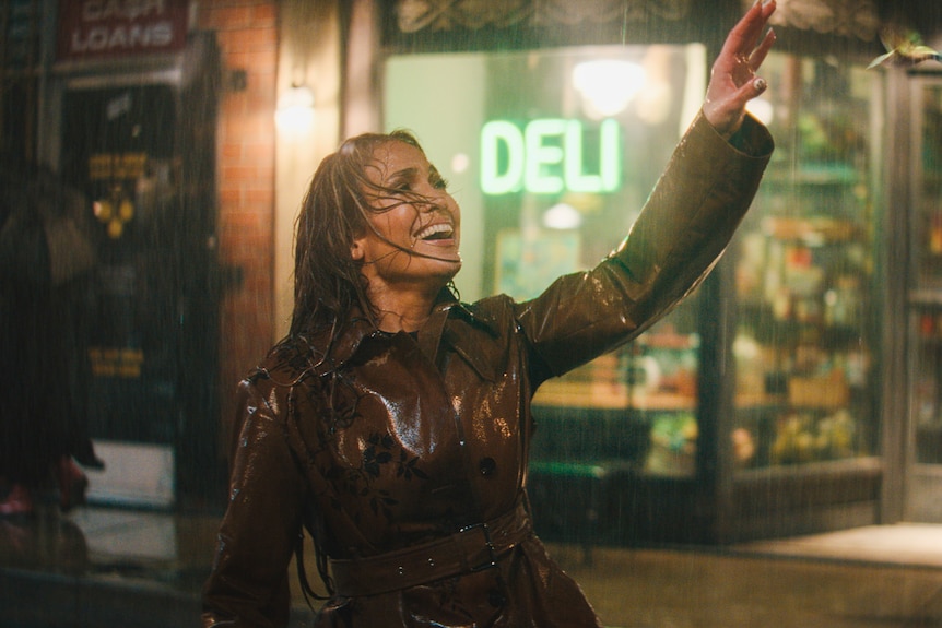 Jennifer Lopez dances in the street in the rain in a scene that echoes the film Singin in the Rain.