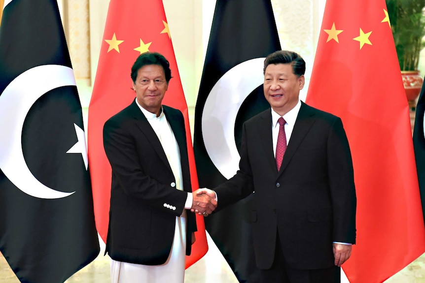 Imran Khan shakes hands with Xi Jinping.