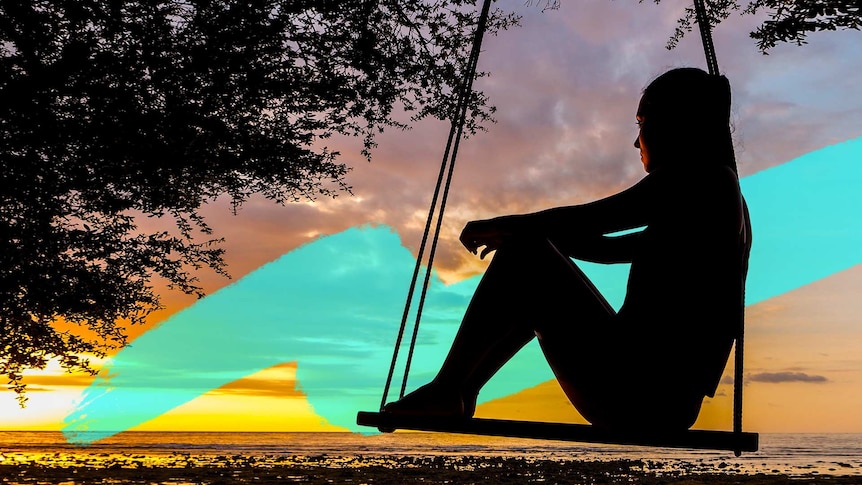 Silhouette of a woman on a swing that is hanging from a tree, with a sunset in the background