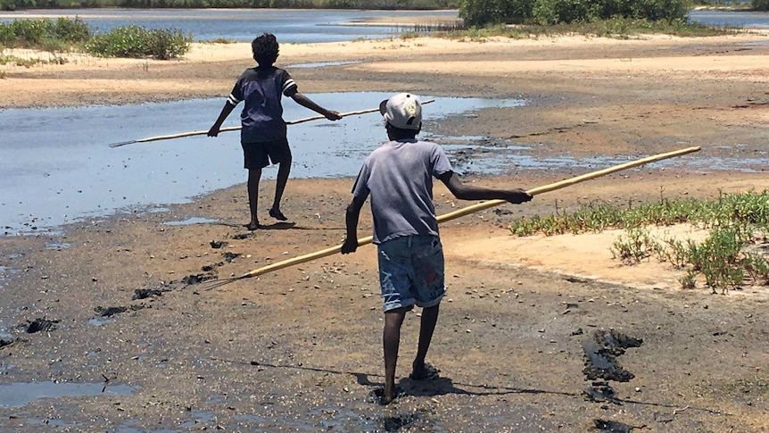 Indigenous children hunting on a beach.