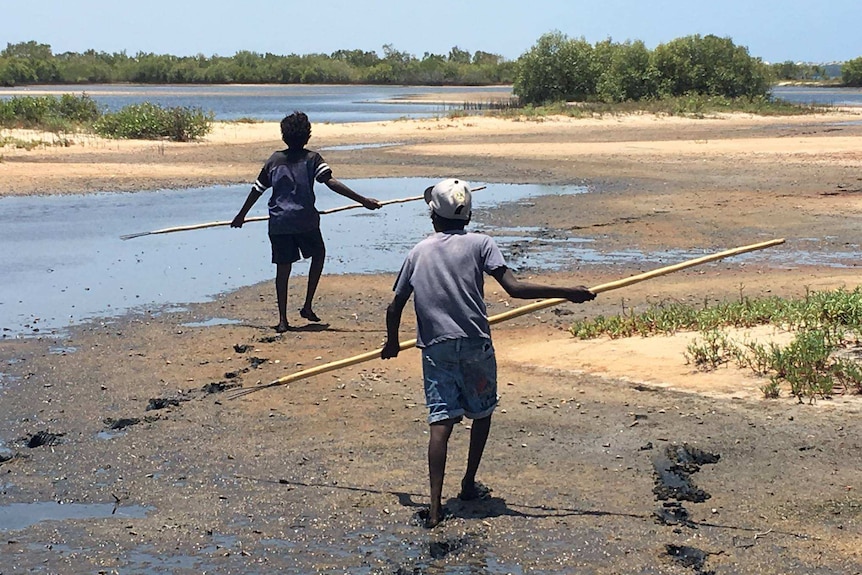 Indigenous children hunting on a beach.