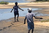 Indigenous children hunting on a beach.