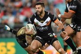 Wests Tigers' James Tedesco (L) runs with the ball against Penrith at the Olympic stadium in 2016.