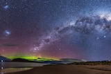A multi-coloured milky way arching across the sky and Aurora Australis.