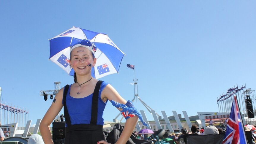 A young girl stands in front of parliament house on Australia Day