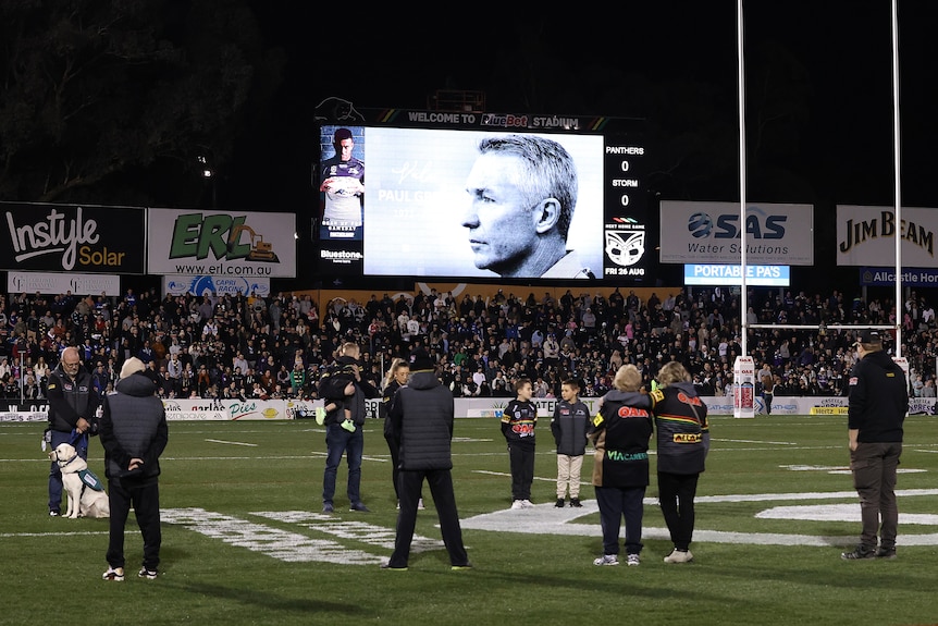 Paul Green's image is displayed on the big screen during a minute's silence before an NRL game at Penrith Stadium.