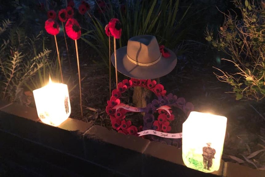 An Anzac Day tribute on a Perth driveway with poppies and candles.