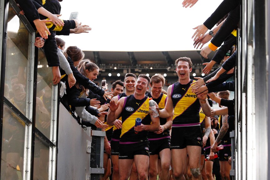 Jack Higgins and Dylan Grimes lead the Tigers off the MCG.