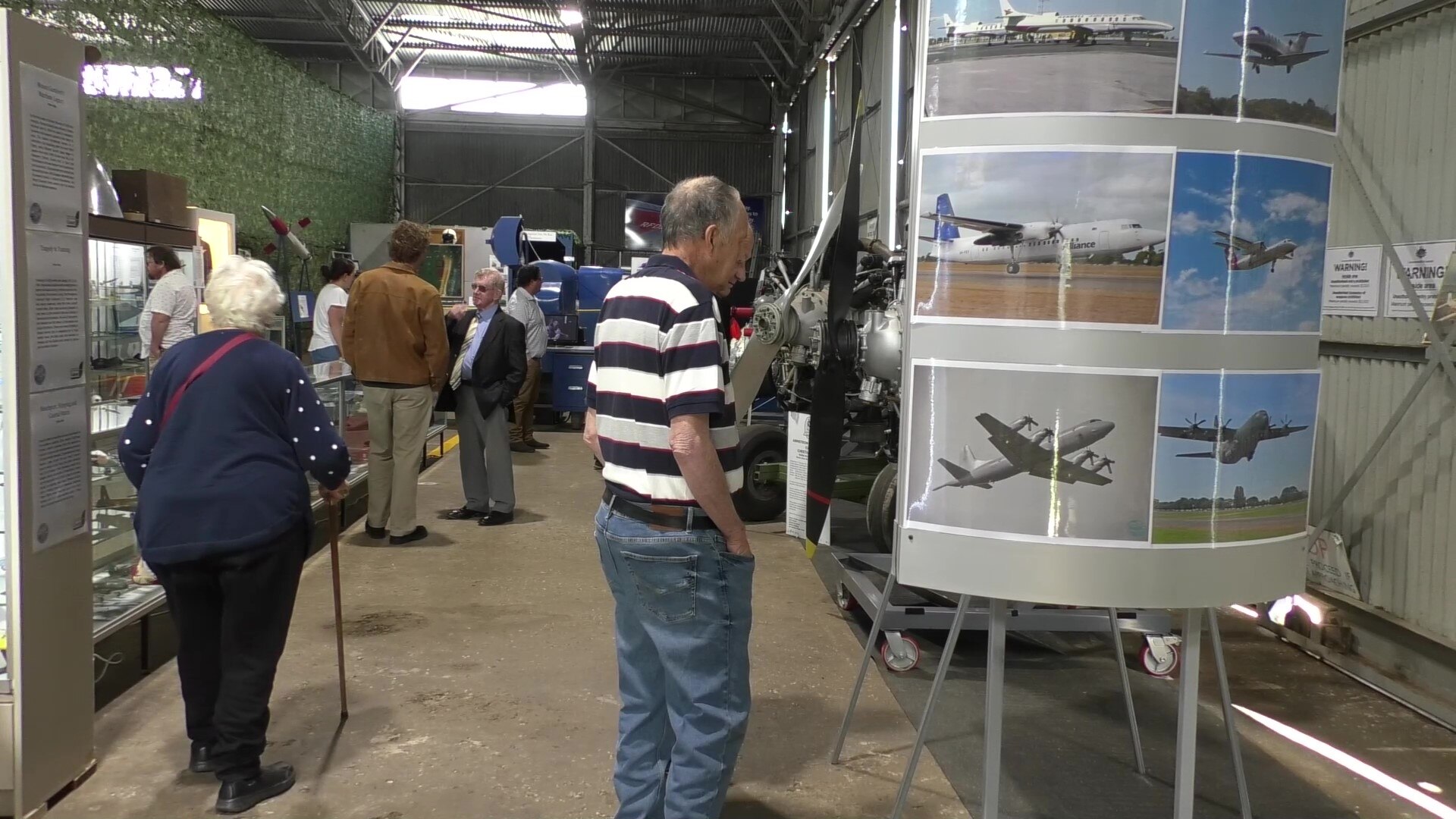 People walking around displays of aeroplanes and other aviation pieces