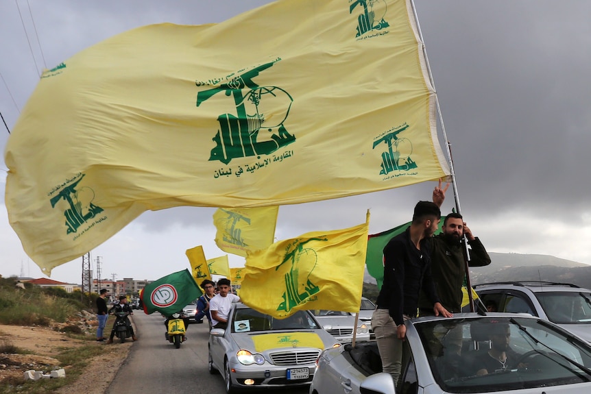 A supporter of Lebanon's Hezbollah gestures as he holds a Hezbollah flag in Marjayoun.
