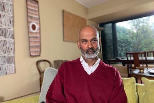 Suresh Sundram, wearing a maroon sweater, looks seriously at the camera.