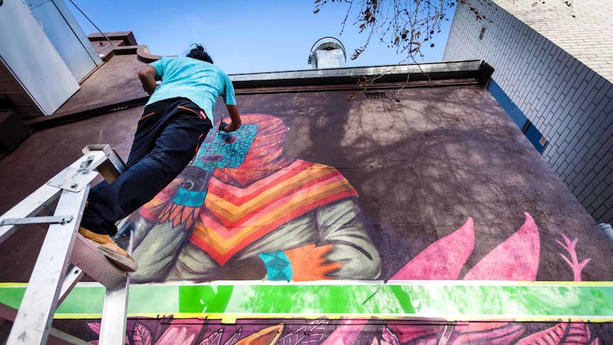 Edgar 'Saner' Flores at work on his mural in Victoria Park.