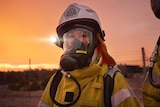 A woman wearing a Hazmat suit with breathing apparatus