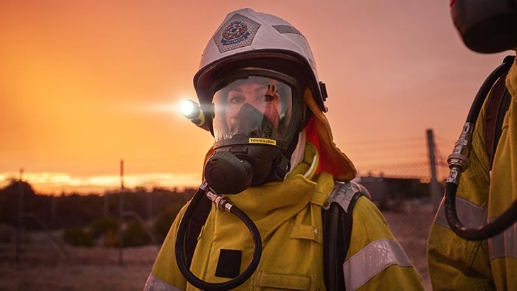 A woman wearing a Hazmat suit with breathing apparatus