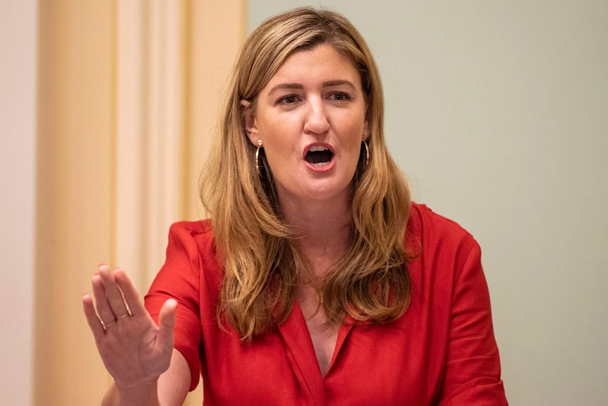 A woman gestures a stop signal as she delivers a speech