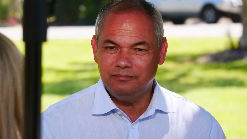 a middle-aged man talks to a reporter