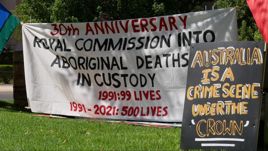 Banners are seen at a black deaths in custody rally in Alice Springs.