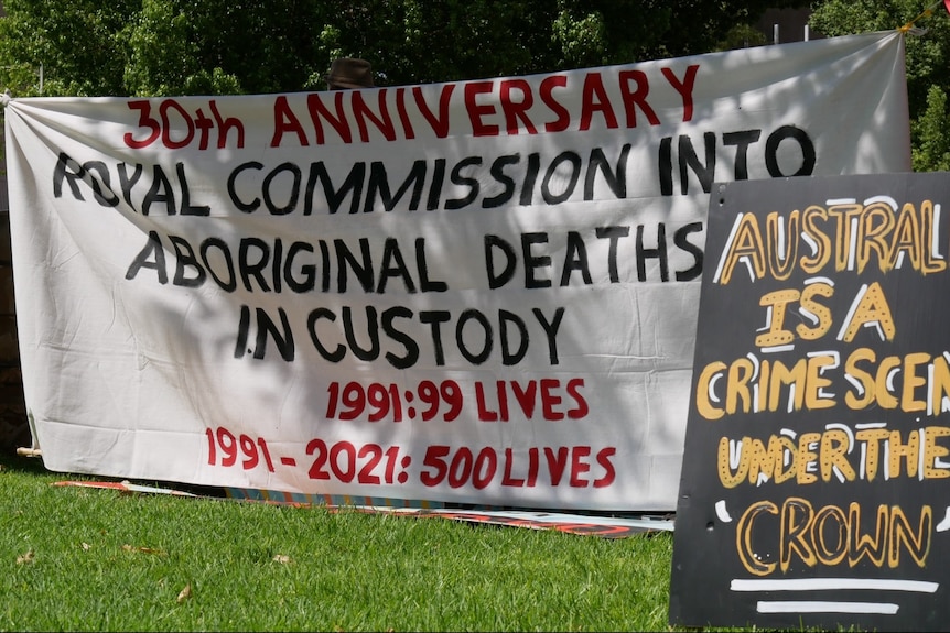 Banners are seen at a black deaths in custody rally in Alice Springs.