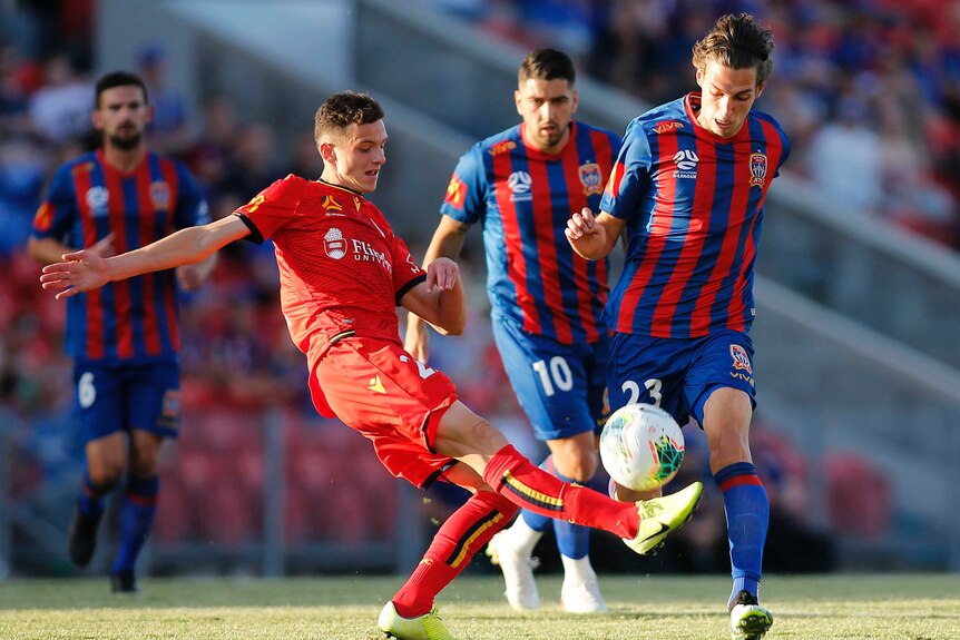 An Adelaide United A-League player kicks the ball against the Newcastle Jets.