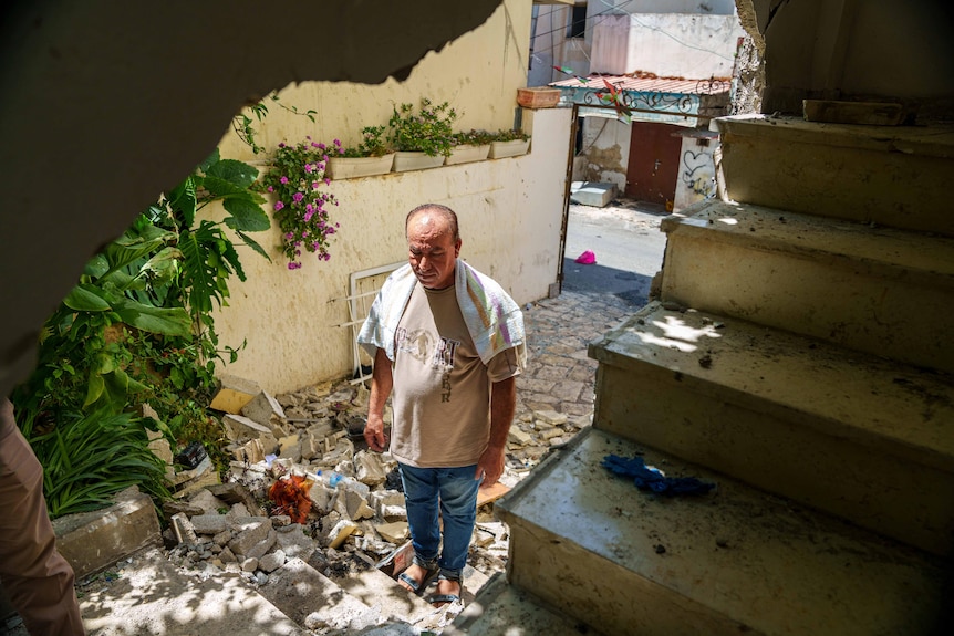 A man walks through rubble 