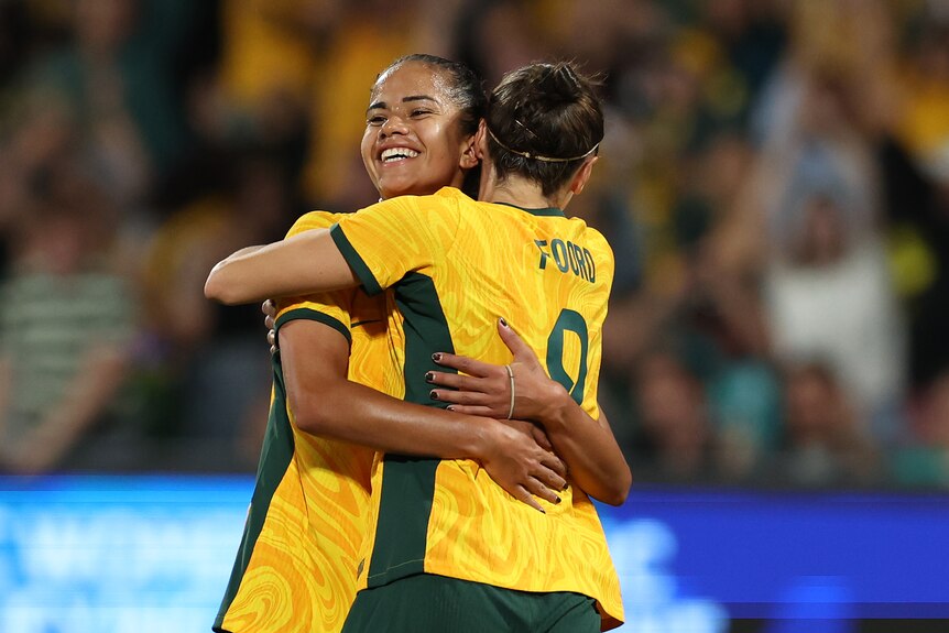 Matildas Mary Fowler and Caitlin Foord hug during an Olympic qualifier against Chinese Taipei.