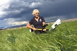 Hannah Robinson holds a 'GreenSeeker' in a barley crop