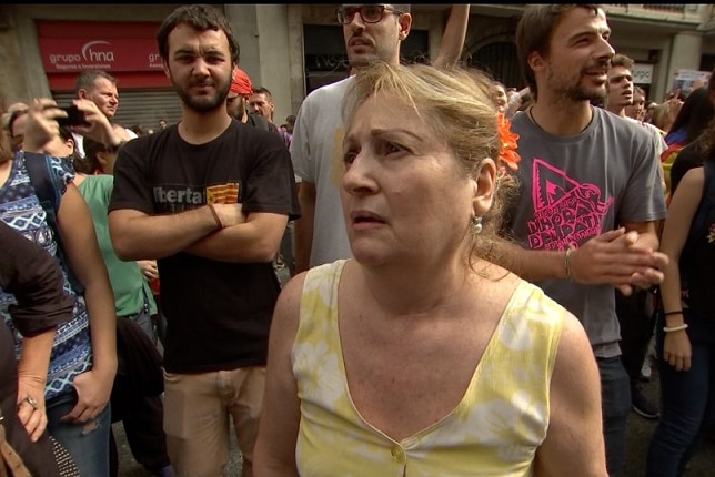 A woman looks concerned as she stands amongst protestors.